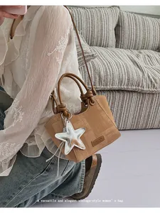Detail of khaki retro handbag with mesh texture, star charm, and round braided handles