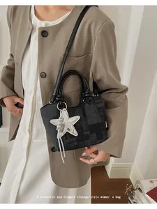 Detail of vintage bucket bag featuring silver star pendant and premium canvas texture