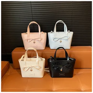 Collection of small tote bags in pink, blue, beige, and black with bow and heart charms