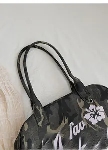 Detail of comfortable camo straps and metal hardware on large capacity tote bag