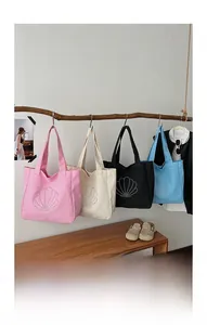 Detail of four colorful canvas tote bags with rhinestone shells hanging on wooden branches