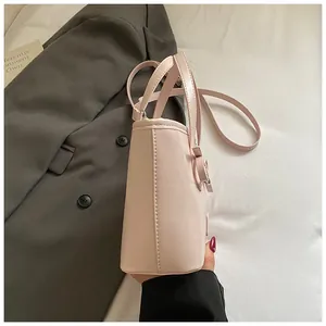 Detailed side view of pink leather tote bag with bow accent on blazer background