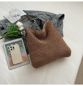 Straw tote bag with striped straps displayed with denim jacket and accessories