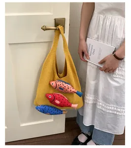 Close-up of yellow knitted tote bag featuring three colorful 3D fish decorations