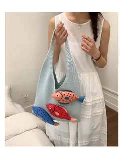 Detail of light blue knit tote bag featuring three colorful 3D fish doll decorations
