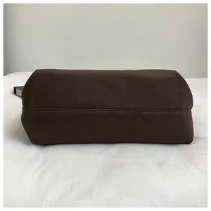 Close-up of the reinforced stitching and durable canvas bottom of the brown tote bag