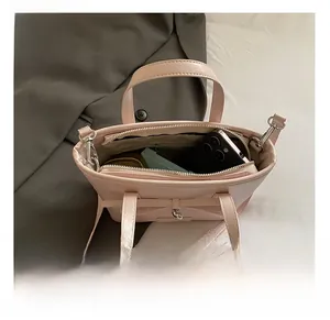 Pink bow tote bag interior showing spacious main compartment for phone and makeup