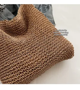 Detail of hand-woven straw shoulder bag showing textured hollow weave and caramel finish