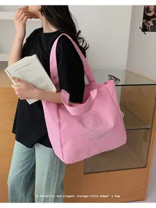 Close-up of pink canvas tote bag with shell rhinestone pattern and dual handles