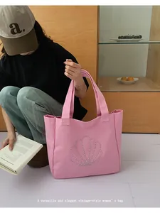 Detail of pink canvas tote bag featuring decorative pearl shell pattern and wide handles