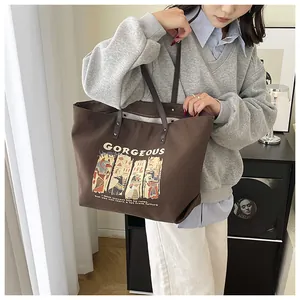 Detail view of a large brown canvas tote bag with Anubis illustration and quotes