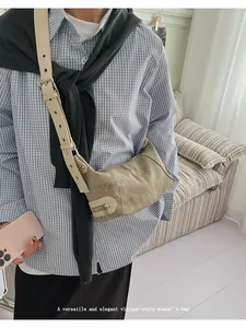 Detail of vintage canvas crossbody bag with silver buckle and eyelet strap design