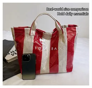 Macro detail of red and white striped waterproof tote bag with phone size comparison
