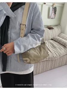 Detail of vintage canvas shoulder bag featuring metal buckle strap and side zipper
