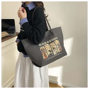 Close-up of a large grey tote bag featuring Egyptian art print and golden typography