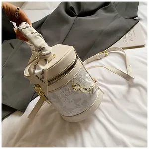 Close-up of bucket bag showing lace embroidery details and silk-wrapped metal handle