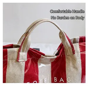 Close-up of red striped tote bag with waterproof PVC layer and durable canvas handle