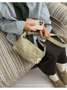Detailed close-up of olive green vintage crossbody bag showing texture and strap buckle