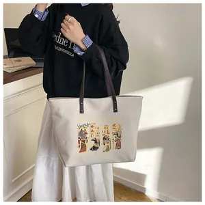 Detailed shot of canvas tote bag with Egyptian Anubis print and brown leather handles