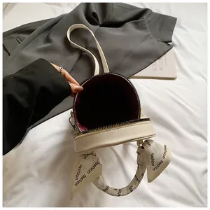 Detail view of cream bucket bag with burgundy lining and silk scarf wrapped handle