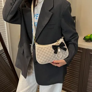 Chic beige underarm bag with M-letter print, black bow detail and pearl pendant