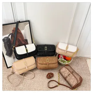 Detail view of stylish crossbody bags in six assorted colors with metallic chain hardware