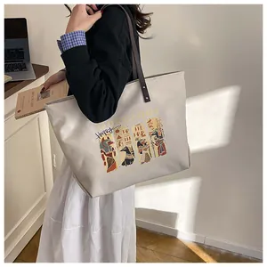 Close-up of canvas tote bag showing Anubis print and dark leather shoulder strap detail