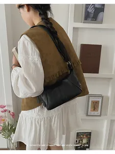 Detail of a black leather handbag with vertical stitching and smooth metallic zipper
