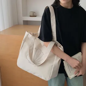 Minimalist off-white canvas tote bag with silver studded shell pattern and large capacity