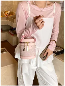 Detailed macro view of pink bucket bag with floral lace and gold lock zipper hardware