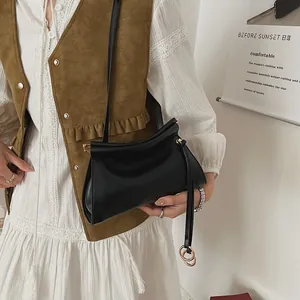 Sac bandoulière minimaliste en cuir noir avec design plissé et anneau doré pour femme