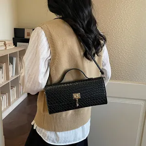 Elegante borsa a mano intrecciata nera con chiusura dorata a tracolla di stile