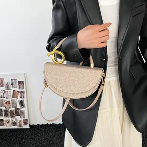 Minimalist beige woven handbag with unique gold metal handle and slim shoulder strap