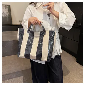 Detail of waterproof striped tote bag with white TOTE BAG lettering and canvas texture