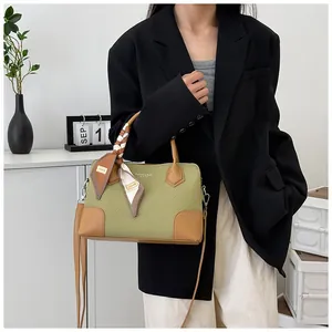 Détail du sac bandoulière tissé vert avec foulard en soie et finitions cuir