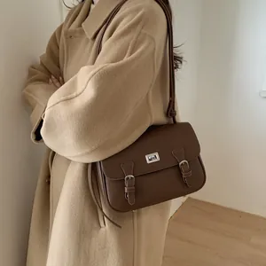 Brown litchi grain messenger bag with vintage buckle straps and silver twist lock