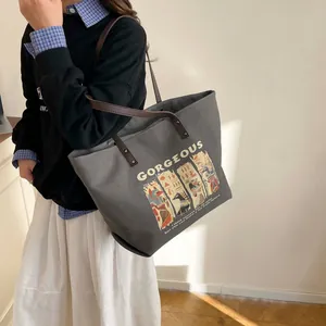 Grey canvas tote bag with brown leather straps and Anubis graphic print for daily use