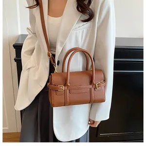 Sac à main marron foncé texture litchi avec détails dorés et poignées arrondies