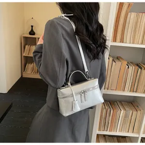 Silver matte boxy handbag shown worn as a crossbody bag in a cozy indoor setting
