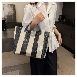 Detail of waterproof striped tote bag with glossy finish and white TOTE BAG text print