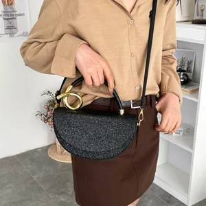 Chic black half-moon shoulder bag with sequined texture and golden twist metal handle