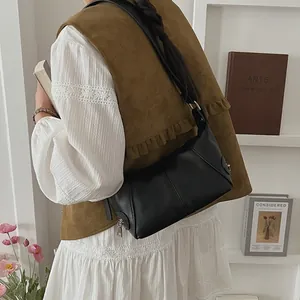 Classic black leather shoulder bag for women shown on a model in a library setting