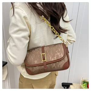 Detail of vintage bronze pleated crossbody bag with brown leather trim and gold chain