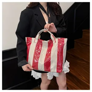 Detail of red and white striped tote bag with waterproof coating and TOTE BAG text