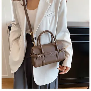 Détail du sac à main en cuir marron grainé avec boucle en métal et bandoulière réglable