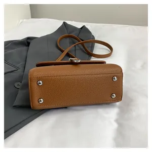 Vue du dessous du sac à main caramel en cuir grainé avec clous de fond argentés