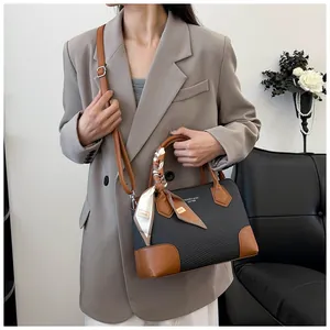 Détail de la texture tissée et de la garniture en cuir marron de ce sac à bandoulière