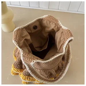 Detail of bohemian knit tote bag showing interior lining, magnetic clasp, and pocket
