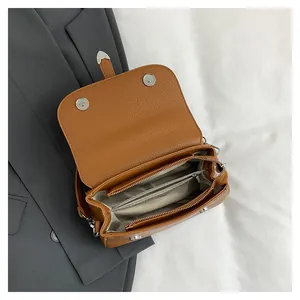 Détail intérieur du sac en cuir marron avec compartiments et poche zippée interne