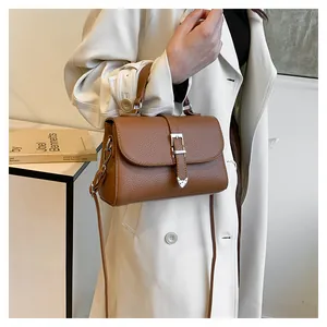 Détail d'un sac à main en cuir marron foncé avec fermoir argenté et motifs de cœur